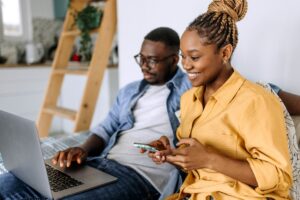Couple engaged in a rental search on their laptop and mobile device.