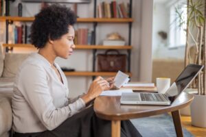 Adult woman paying bills in her home.