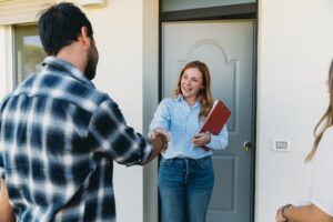 A happy property manager greets a tenant at the door.