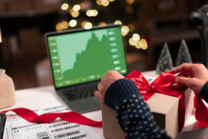 Real estate professional at their desk working on a laptop showing statistics, graphs during the holiday season. 