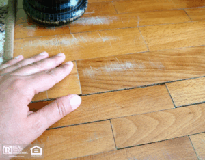 Scratched old parquet flooring needing maintenance.