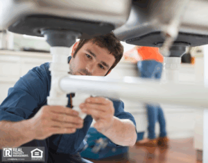 Knowledgeable renter working on pipes underneath sink.