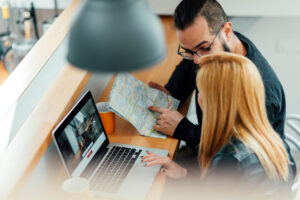 A young couple looking at their laptop to rent an apartment.
