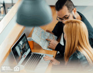 A young couple looking at their laptop to rent an apartment.