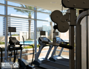 A man drafting a maintenance budget in a notebook with a pen, next to a house model on the table.