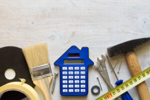 DIY tools and calculator on wooden white background. 
