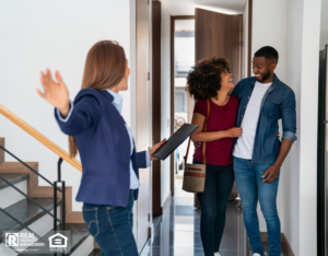A property manager shows a happy couple their home.