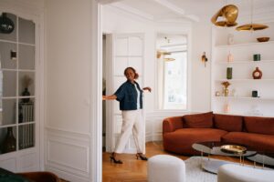 A happy tenant walks into her apartment living room.