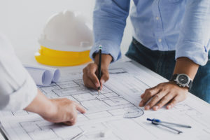  working with partner and engineering tools working on blueprint architectural project at the construction site at desk in the office.