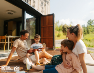Photo of a family with two young children lounging on the front deck of their vacation house.