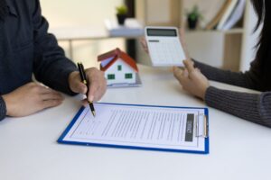 Real estate agents calculate and quote the cost of house with a calculator.