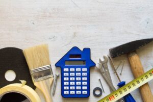 DIY tools and calculator on wooden white background.