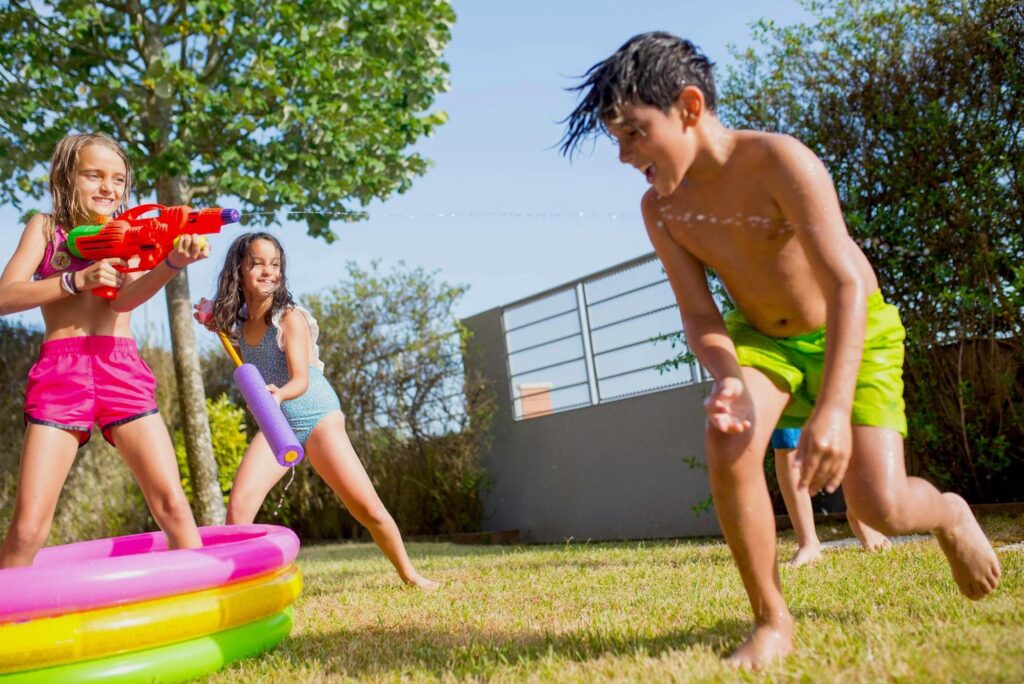 children playing water games in the backyard of a Miramar rental property