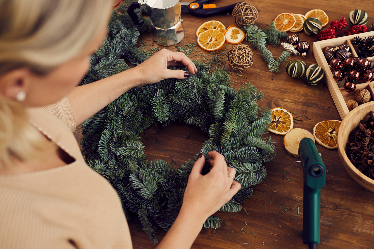 Woman Crafting a Winter Wreath with Hot Glue Gun