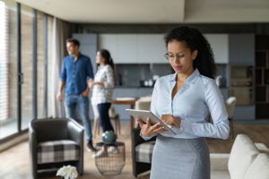 Property manager showing a house to a couple and using a tablet computer. 