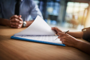 Two people completing paperwork together at a desk