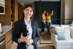 Smiling property manager with happy tenants looking at the home. 
