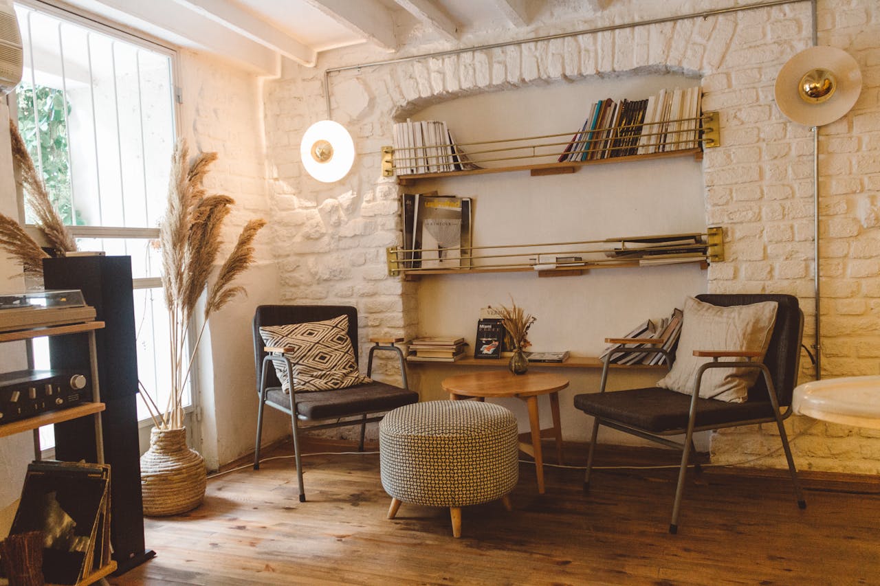 living room with white stone walls, bookshelf, striped furniture