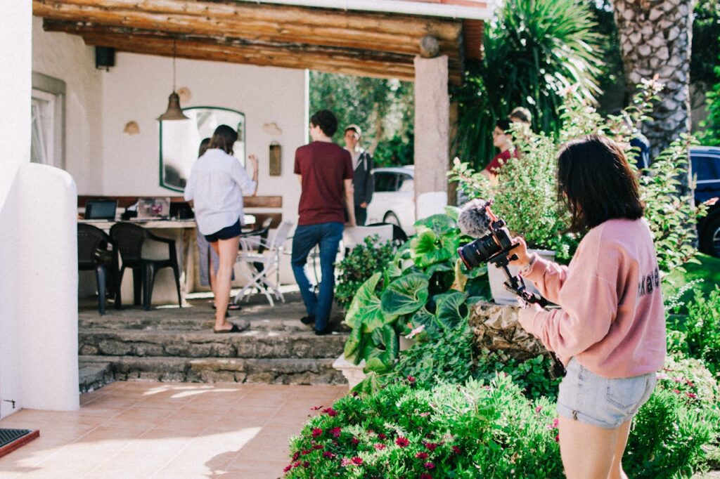person with camera in front of house